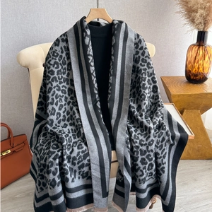 Classic leopard print thick scarf with pink tassels on black turtleneck background