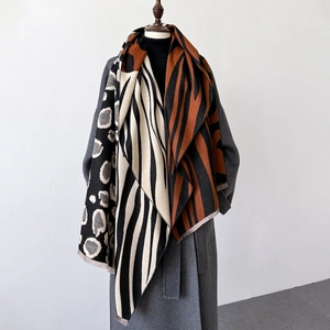 Detail of leopard and zebra pattern cashmere-like scarf with fringe on wool coat