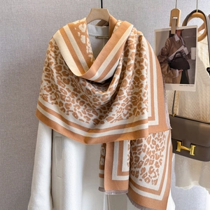 Thick leopard print scarf with fringe trim draped over a stylish coat for autumn winter