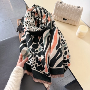 Detailed view of leopard print faux cashmere scarf with elegant fringe and soft texture