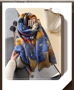 Détail d'une écharpe douce avec motif d'élan bleu et orange et bordures à franges