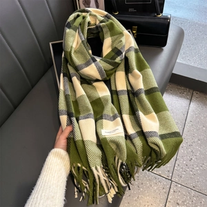 Detailaufnahme des grün-beigen Karoschals mit weicher Strickstruktur und Fransen