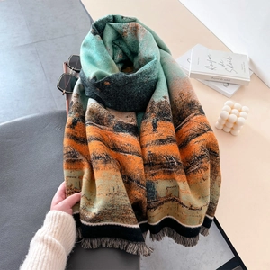 Artistic oil painting scarf with landscape print and tassels on a styled tabletop