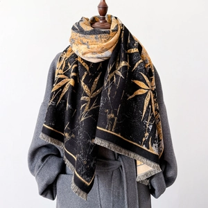 Elegant black thick shawl with golden bamboo pattern and tassels on gray wool coat