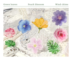 Close-up of semi-transparent floral and green leaf stickers for journal decoration