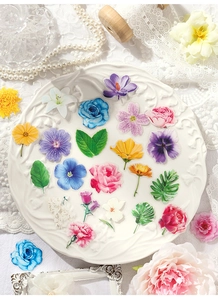 Close-up of floral stickers with roses and lilies displayed on a vintage ceramic plate
