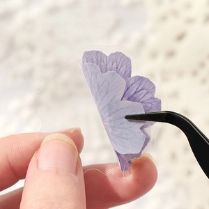 Transparent PET purple flower stickers for journaling shown with tweezers for detail