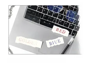 Close-up of torn colorful label stickers with color names on an office desk setup