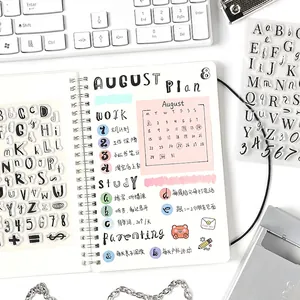 Transparent alphabet and number silicone stamps set for DIY planners on a white desk