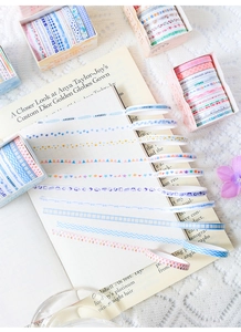 Detail of decorative washi tape set featuring plaid patterns and floral designs on a notebook