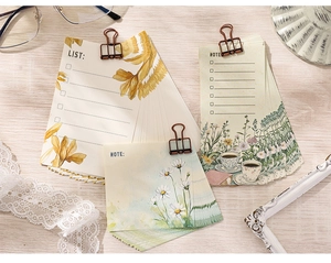 Detail of vintage floral stationery set with watercolor flower notes and a bronze clip