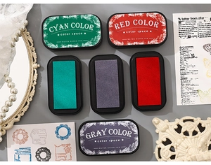 Macro shot of rectangular water-based ink pads with cyan, red, and gray color options