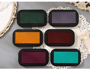 Detail of 6-color water-based ink pad set on elegant lace background for DIY crafts