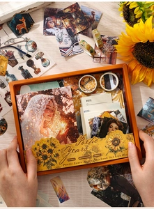 Close-up of hands holding vintage floral scrapbook gift set with stickers and tapes
