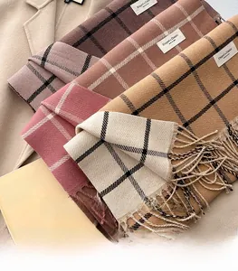 Detail of soft plaid cashmere-feel scarf showing elegant fringe and classic woven texture