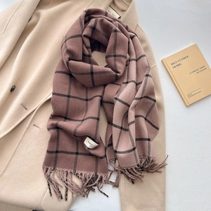 Brown checkered thick scarf with fringe tassel on beige coat and vintage book