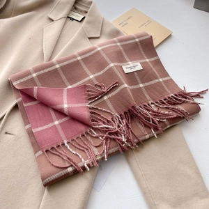 Elegant pink and brown plaid cashmere-like scarf with long tassels on beige wool coat