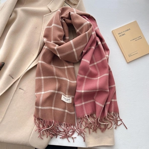 Pink and beige plaid cashmere-feel scarf with tassels layered on a beige wool coat