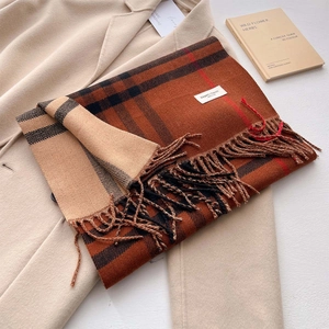 Dettaglio di sciarpa classica a quadri con frange e etichetta su cappotto beige
