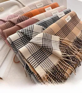 Detailed view of British plaid scarves with tassels in various warm color palettes