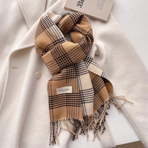 Detail of classic checkered scarf texture with elegant fringes on wool coat