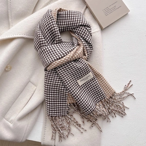 Sciarpa classica pied de poule con dettagli di frange su uno sfondo di cappotto beige