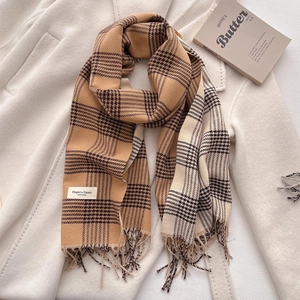 Plaid tassel scarf in beige and brown check pattern on a wool coat