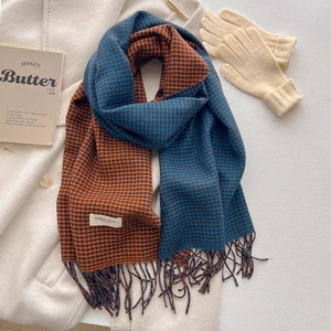 Sciarpa pied-de-poule blu e arancione a contrasto con nappe su un cappotto di lana