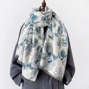 Detail of floral printed winter shawl scarf with gray tassels on a coat outfit