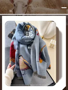 Detail of blue knit scarf featuring a colorful bird pattern and delicate fringe trim