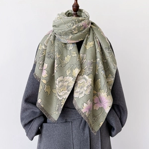 Green vintage floral thick pashmina shawl with tassel edge on a gray coat