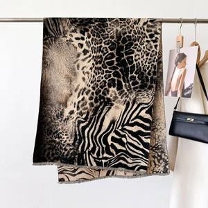 Close-up of leopard and zebra print shawl scarf with soft fringes and tassel details