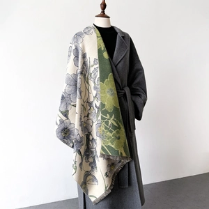 Double-sided floral jacquard scarf with tassels shown on a gray wool coat