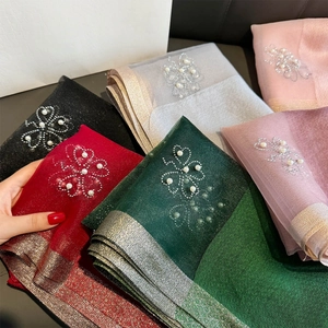 Detail of four-leaf clover pearl and rhinestone embellishments on sheer scarves