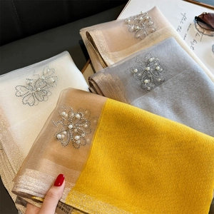 Detail of silk wool scarves with beaded butterfly patterns and rhinestone accents