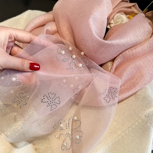 Macro detail of pink sheer scarf with exquisite faux pearl and rhinestone floral embroidery