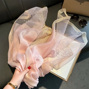 Close-up of pink champagne shawl with sparkling rhinestones and pearl floral details