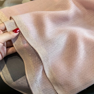 Detail of light pink scarf with delicate mesh texture and sparkling golden glitter borders