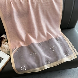 Pink and grey gauze shawl with delicate pearl floral embroidery on a sofa display