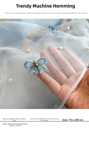 Détail d'une écharpe en soie bleu clair avec broderie papillon et perles élégantes