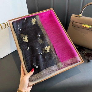 Détail d'une écharpe en soie avec broderie papillon dorée et perles sur tissu bicolore