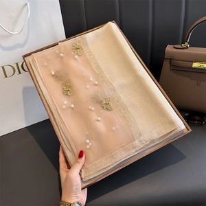Détail d'un châle champagne effet soie avec broderies de perles et ornements papillons