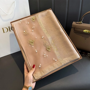 Détail du châle champagne avec appliques papillon dorées et perles de fantaisie