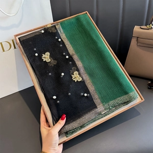 Détails de broderie papillon dorée et perles sur une écharpe élégante en soie vert et noir