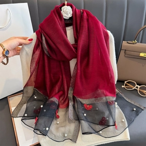 Détail de l'écharpe en soie bordeaux avec broderie papillon et perles blanches