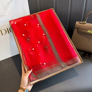 Détail d'une écharpe en soie rouge avec broderie papillon 3D et ornements de perles