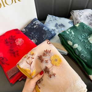 Dettaglio dei ricami floreali premium su sciarpe di seta eleganti e lussuose per donna