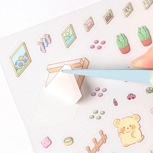 3D miniature scene stickers with cute bear designs being picked up with tweezers
