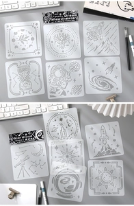 Macro shot of space and nature themed stencil sheets for painting on a gray desk