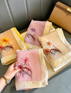 Detail of embroidered floral patterns on sheer silk scarves with gold trim edges